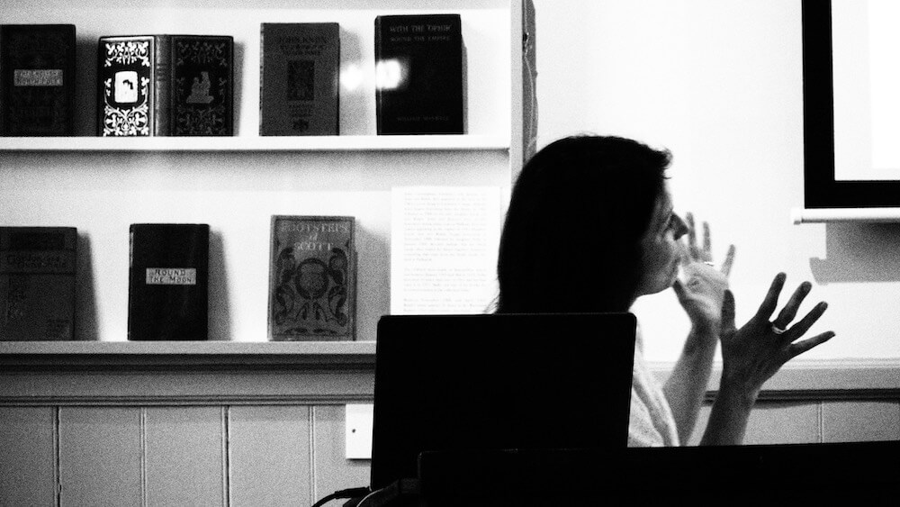 artist talk - black and white photo of female artist giving a presentation
